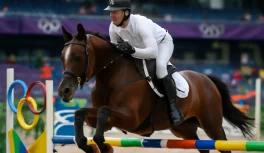 Atleta do pentatlo moderno em prova de hipismo com obstáculos coloridos